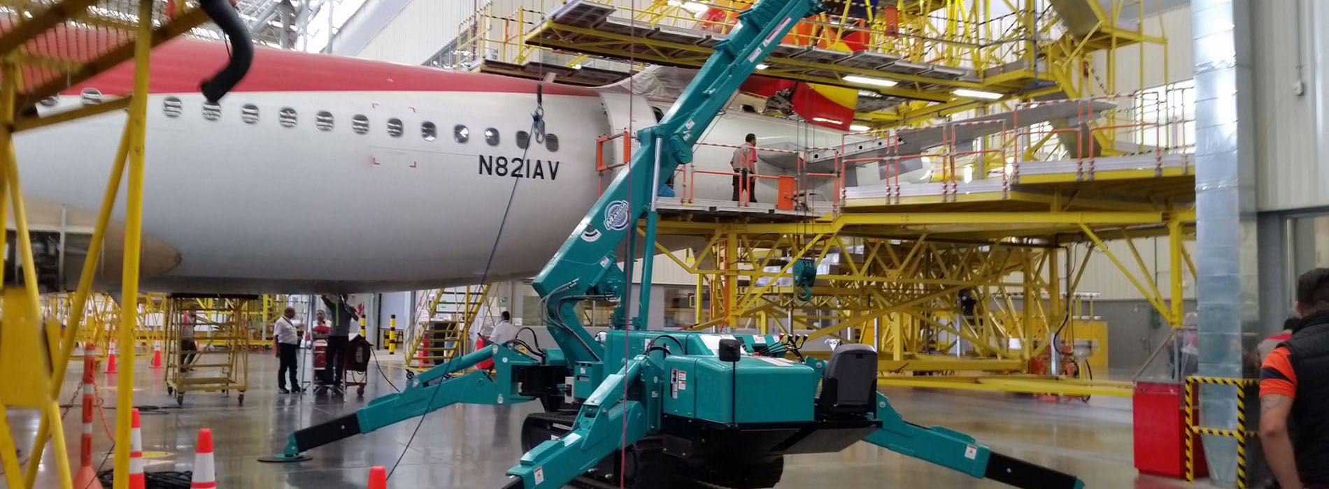 Grúa araña MAEDA trabajando en un avión dentro de las instalaciones de mantenimiento
