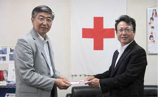 Un miembro de MAEDA hace una donación a la Cruz Roja Japonesa